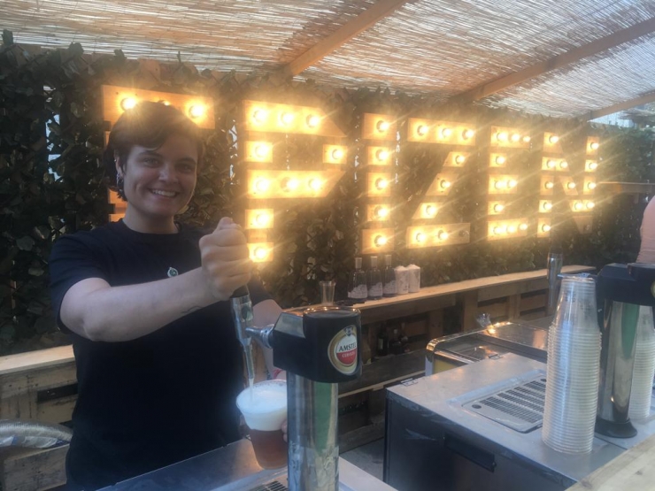 Una treballadora servint una cervesa a la zona 